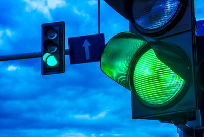 Close up of traffic lights over urban intersection.