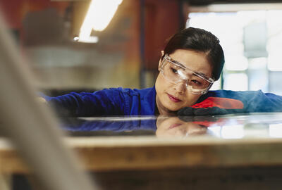 Womale wearing safety glasses and gloves watching a process closely.
 Womale wearing safety glasses and gloves watching a process closely.