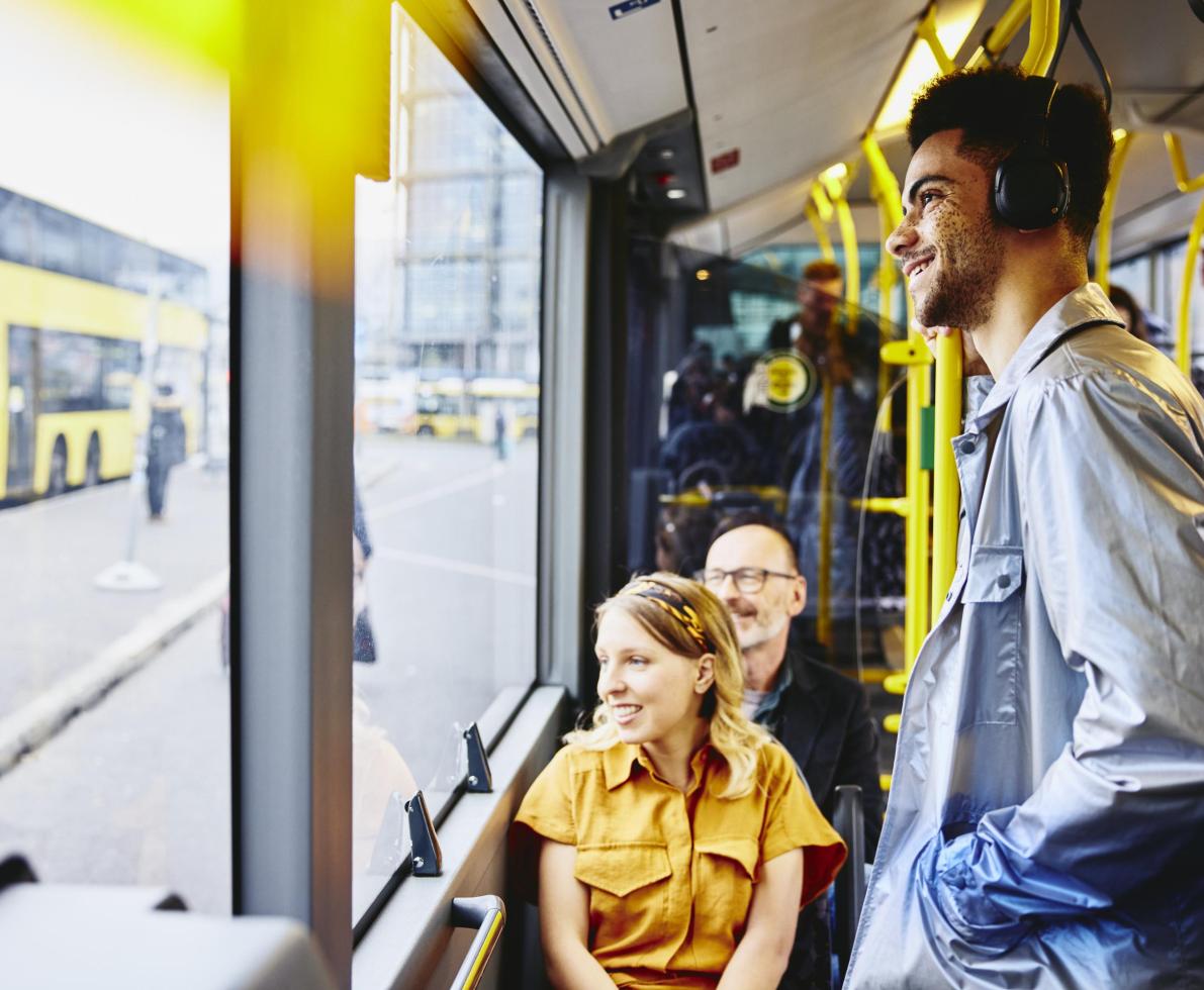 Smiling people looking outside from the bus.