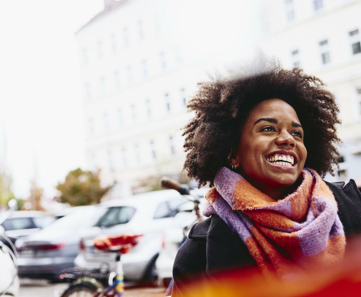 Smiling woman looking up while walking outside. Smiling woman looking up while walking outside.