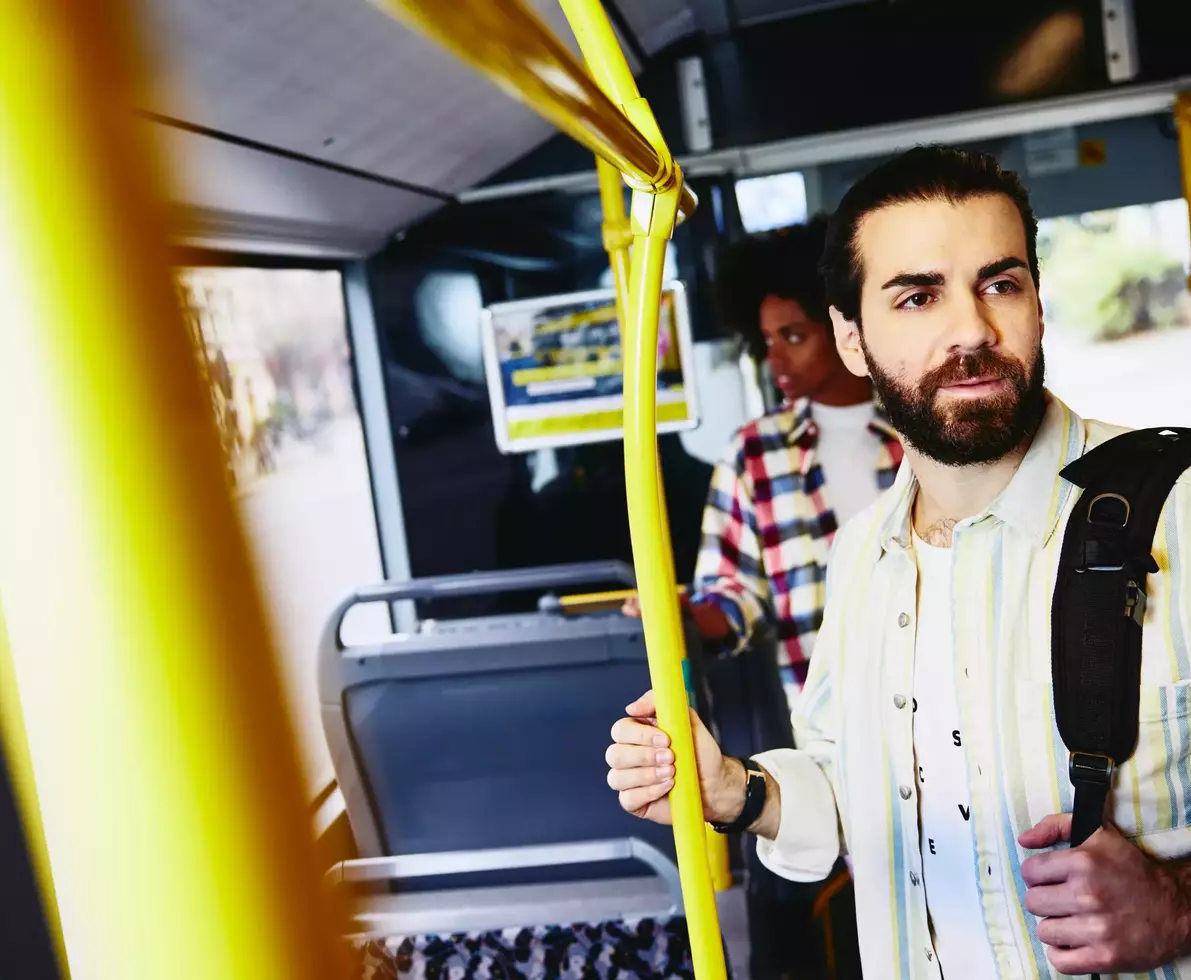 male standing in bus.
