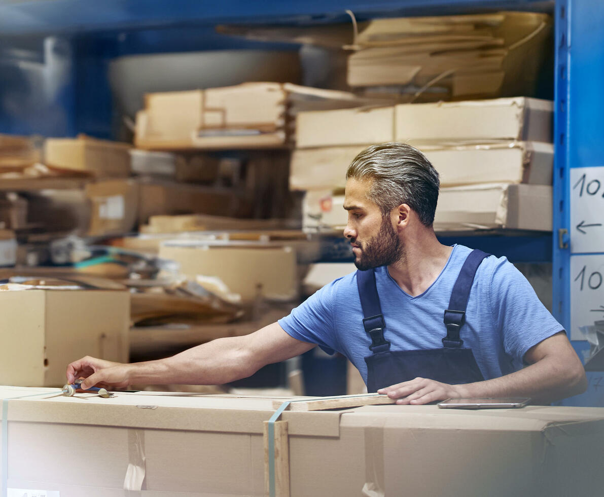 male busy with parcels in a distribution center/warehouse.
 male busy with parcels in a distribution center/warehouse.