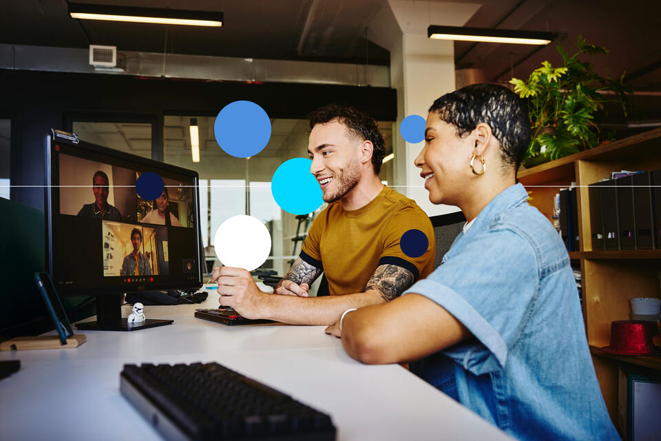 Man and woman sitting behind a computer in a video meeting.