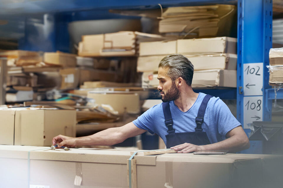 male busy with parcels in a distribution center/warehouse.
 male busy with parcels in a distribution center/warehouse.